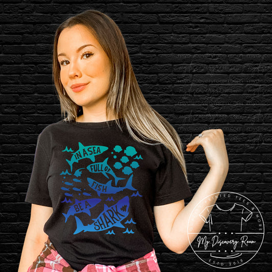 In A World Full Of Fish Be A Shark Graphic Tee